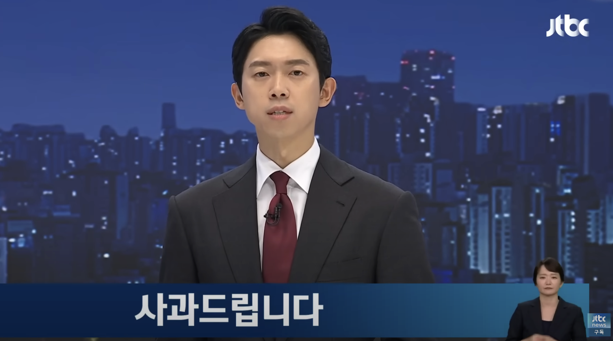 A male anchor on JTBC newsroom in a suit. A sign language interpreter is in the bottom right. The screen reads "Apologies" in Korean.