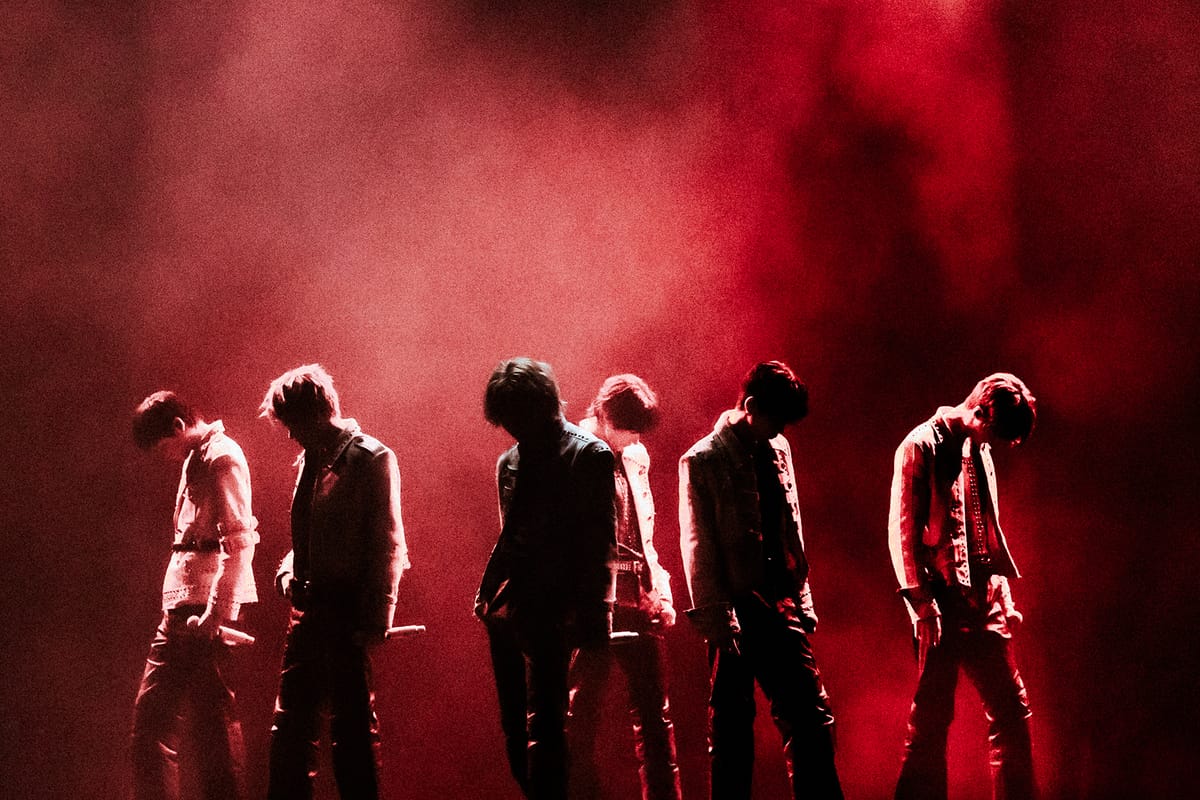 RIIZE on stage, shadowed in red and black