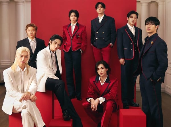 Stray Kids posing in their Met Gala suit outfits in red, white, and navy blue.