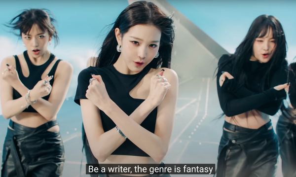 Three members of IVE with the lyrics "Be a writer, the genre is fantasy" in subtitles. 